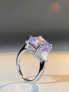 Macro shot of 5ct radiant cut lavender stone ring with pear shaped side diamonds