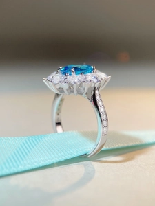 Gros plan d'une bague aigue-marine avec double halo de diamants et zircons
