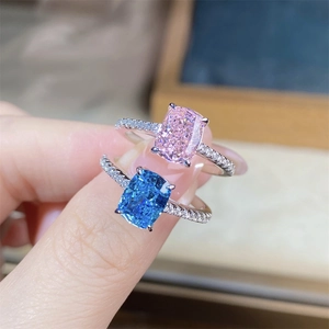 Close-up of cushion-cut pink and blue aquamarine silver rings with pavé diamond bands