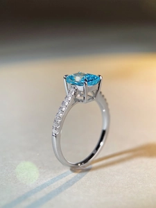 Close-up of radiant cut light blue gemstone ring with sterling silver pave setting