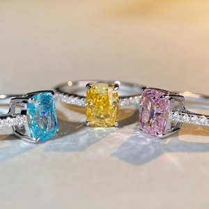 Detail showing three radiant cut rings with sky blue, yellow, and pink gems in silver