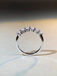 Macro detail of silver band ring featuring seven sparkling round cut zircons in prong setting