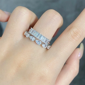 Close-up of stacked S925 silver rings with baguette and pear cut zircon on hand