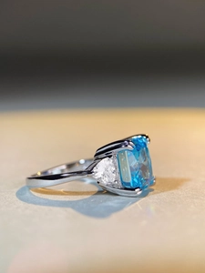 Macro detail of 5ct aquamarine blue rectangle gemstone with trillion cut side stones