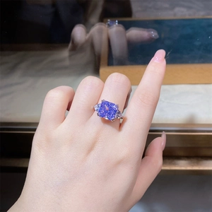 Macro shot of 5ct radiant cut lavender purple stone ring on hand with silver side stones