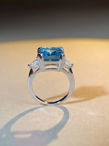 Macro shot of 5 carat emerald cut aquamarine ring with side triangular zircon stones