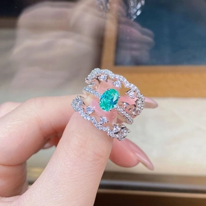 Detailed macro view of S925 silver stacked rings with a green oval gemstone and pavé diamonds