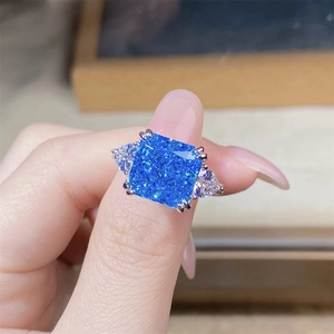 Macro shot of 5ct cushion-cut blue gemstone ring with pear-shaped side stones