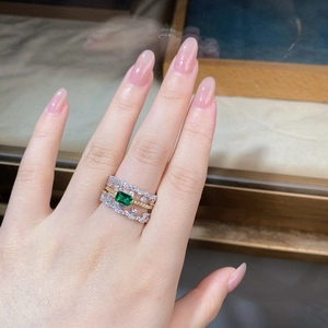 Detail of S925 silver ring featuring emerald-cut green stone and triple-layer pave bands
