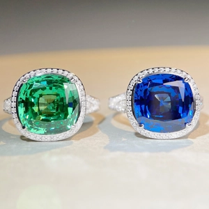 Vue macro de bagues émeraude et saphir taille coussin avec anneaux en pavé de diamants