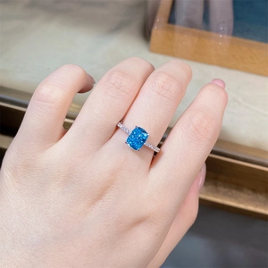 Macro shot of S925 silver ring featuring a radiant cut blue gemstone and pave zircons