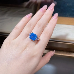 Macro shot of a 5 carat square aquamarine ring with side stones on a model's finger