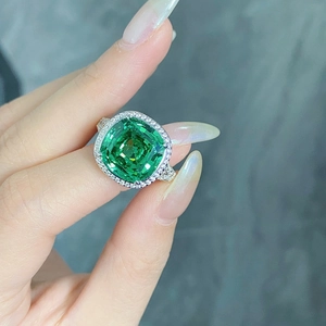 Close-up of cushion-cut green gemstone ring with white zircon pave setting on sterling silver