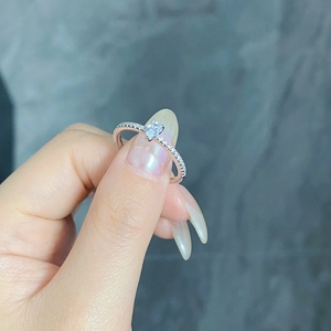 Macro shot of silver teardrop ring with pear-cut zircon and micro-pave setting on hand