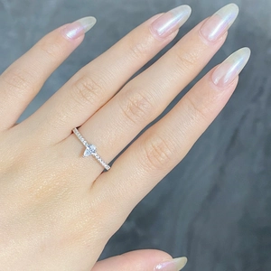 Detailed close-up of a pear-shaped zircon ring with micro-paved silver band on finger