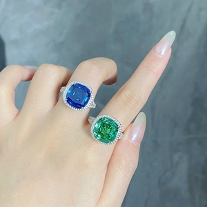 Détail de bagues serties d'une pierre bleue et verte de taille coussin en argent