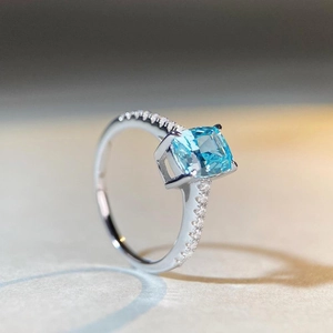 Radiant cut aquamarine S925 sterling silver ring with pavé side stones on a grey surface