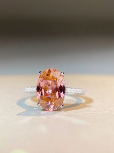 Macro shot of 6 carat oval pink sapphire ring in 925 silver with micro-pave diamonds