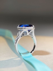 Macro d'une bague en argent S925 avec saphir bleu et pavé de diamants sur de la soie