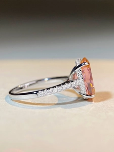 Side view of 6-carat oval pink sapphire ring with pavé diamonds in silver finish