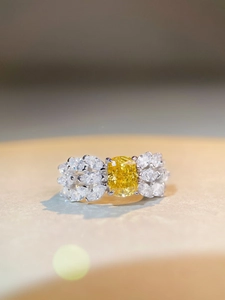 Macro shot of 2ct yellow radiant cut gemstone ring with silver feather side stones