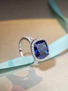 Macro d'une bague saphir taille coussin avec halo de diamants et anneau pavé