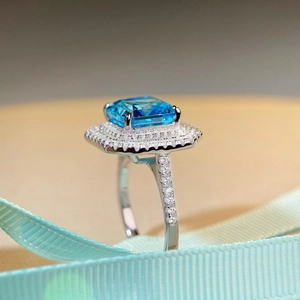 Macro shot of Radiant-cut aquamarine ring with pavé diamonds on blue silk ribbon