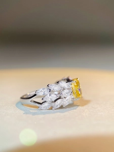 Macro shot of silver ring with 2ct yellow radiant cut stone and marquise accents