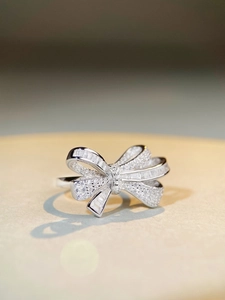 Detailed close-up of bow ring with sparkling zircons and silver metal texture