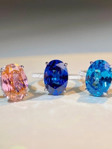 Macro shot of oval cut sapphires in pink, dark blue, and light blue with pave setting