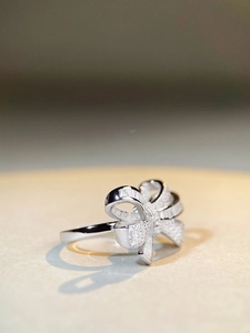 Macro view of a silver bow ring with shimmering zircon micro-pave and baguette stones