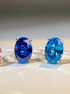 Macro shot of oval cut aquamarine and royal blue gemstone rings with micro-pave diamonds