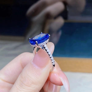 Macro shot of a 6-carat oval blue sapphire halo ring set in polished 925 silver