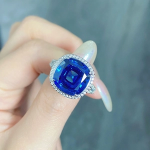 Vue détaillée d'une bague avec saphir bleu taille coussin et halo de diamants