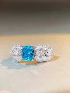 Macro detail of S925 silver ring featuring a blue cushion-cut gemstone with icy flower accents