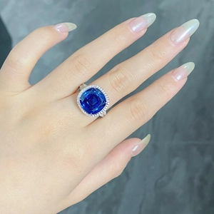 Gros plan d'une bague en argent S925 avec saphir bleu taille coussin et halo diamant