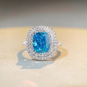 Luxurious sterling silver ring with cushion cut blue zircon and double halo diamonds