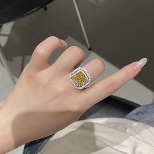 Gros plan d'une bague en argent S925 avec pierre jaune taille radiant et halo de diamants