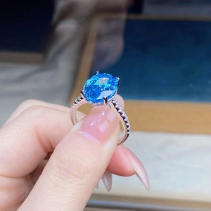 Macro view of oval aquamarine gemstone ring with pave diamonds on a silver band