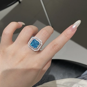 Close-up of radiant cut aquamarine silver ring with double halo diamond setting