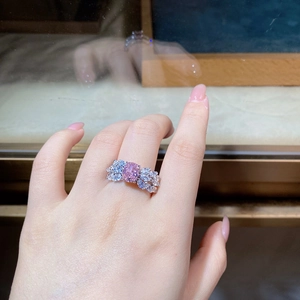 Detail of s925 silver ring with pink oval gemstone and blue accent side stones on hand