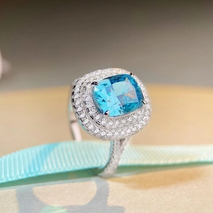 Square blue topaz sterling silver ring with double halo diamonds on light blue ribbon