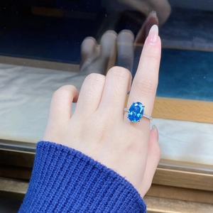 Macro shot of oval aquamarine gemstone ring with micro-pave silver setting on finger