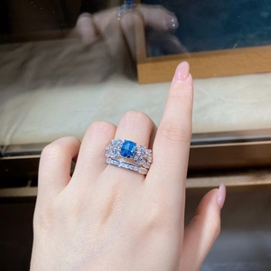 Macro shot of S925 silver ring with rectangle blue gem and sparkling butterfly wings
