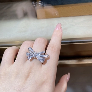 Macro shot of silver bow ring with shimmering zircon stones on a model hand
