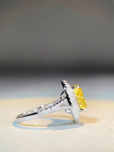 Macro side view of luxury S925 silver ring featuring a large oval yellow gemstone with halo diamonds