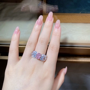 Close-up of S925 silver ring with pink oval stone and bow-knot side accent on a finger