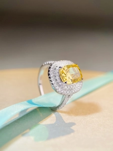 Detailed macro view of a luxury S925 silver cushion cut yellow gemstone ring with diamonds