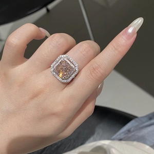Close-up of cushion-cut champagne diamond ring with double halo setting on hand