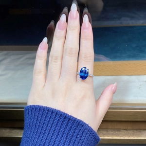 Macro detail of oval blue sapphire ring with pavé diamonds on a sterling silver band